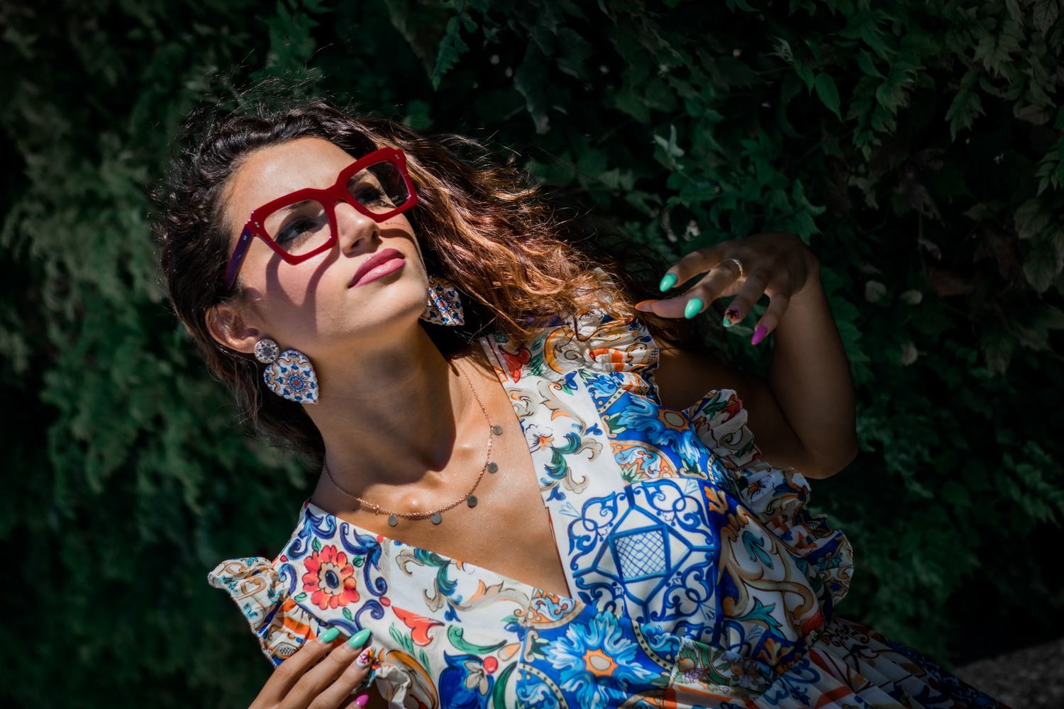 Ragazza con occhiali da vista rossi tra le foglie